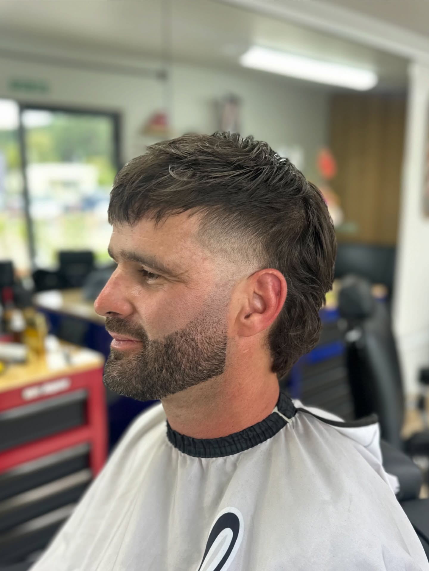 Side view of a French crop with a trimmed beard.