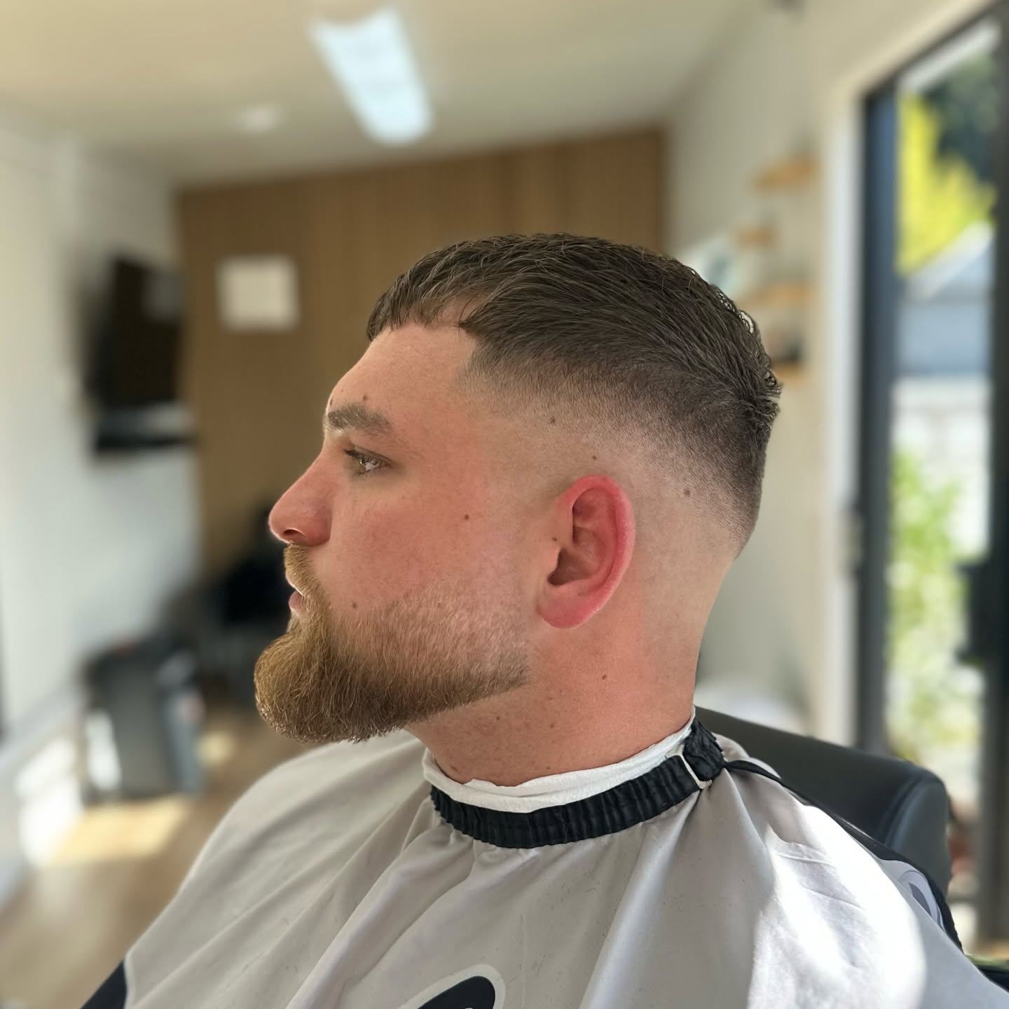 Side view of a short back and sides with a trimmed beard.